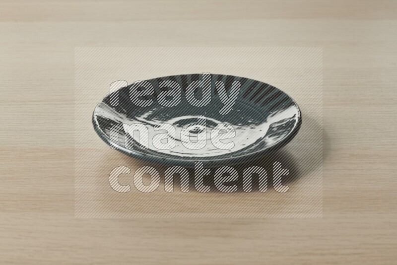 A multicolored pottery plate on light wooden background
