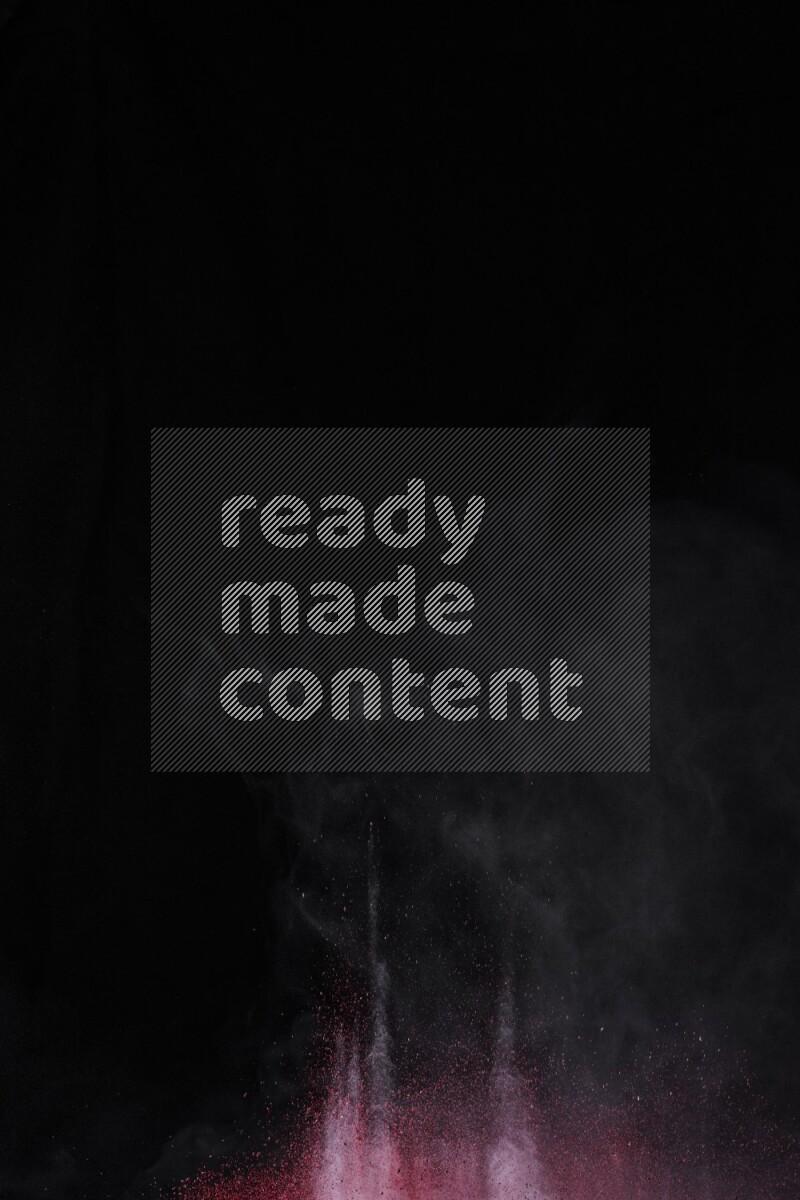 A side view of red powder explosion on black background