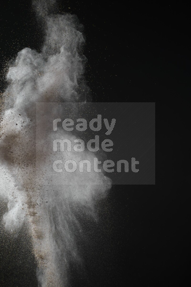 A side view of brown powder explosion on black background