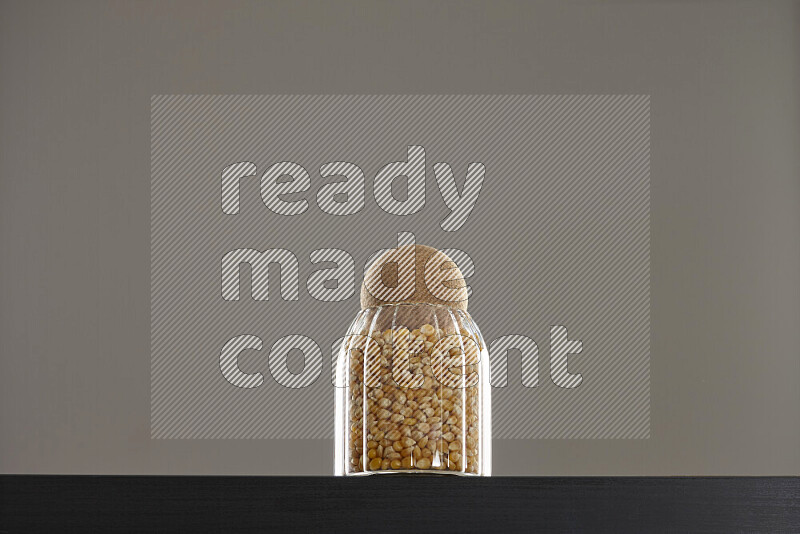 Pop corn in a glass jar on black background