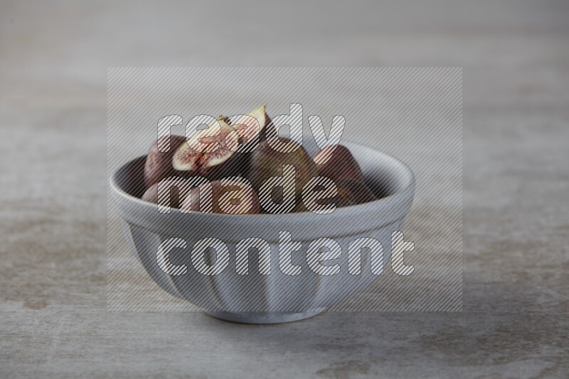 Fresh figs in a bowl on textured grey background