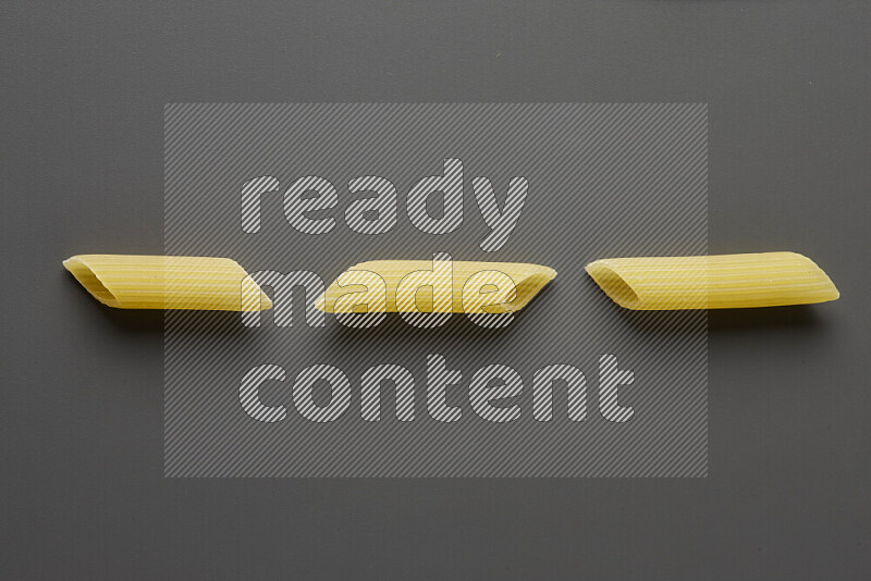 Penne pasta on grey background