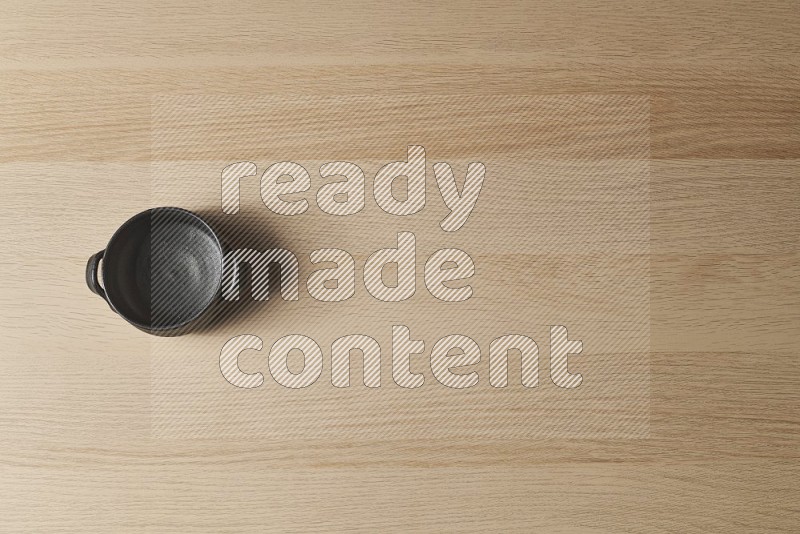 Top View Shot Of A Black Pottery Bowl on Oak Wooden Flooring