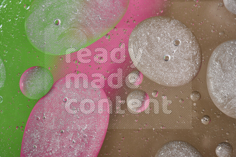 Close-ups of abstract oil bubbles on water surface in shades of brown, green and pink