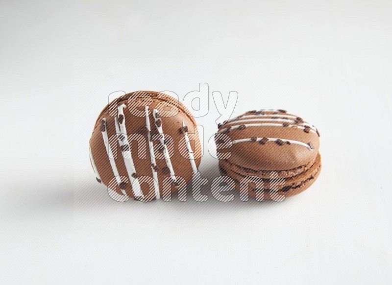 45º Shot of two Brown white Chocolate Caramel macarons on white background