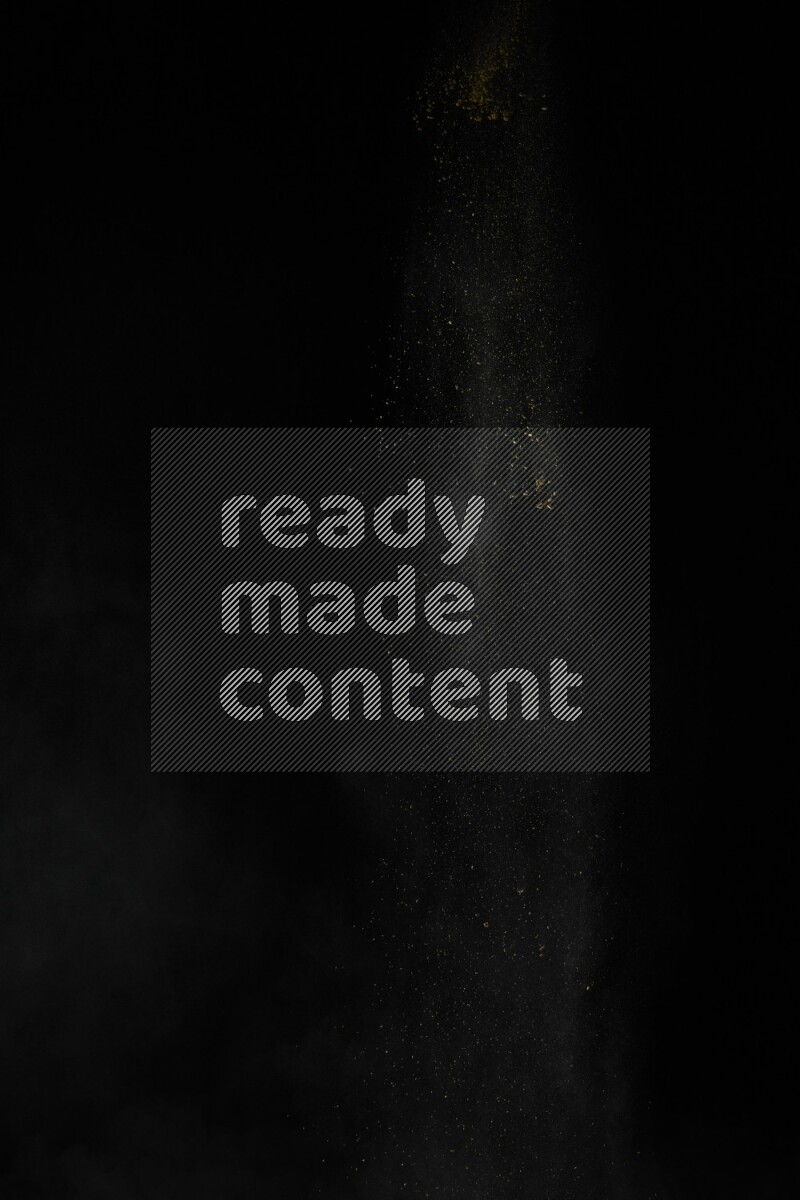 A side view of yellow powder explosion on black background