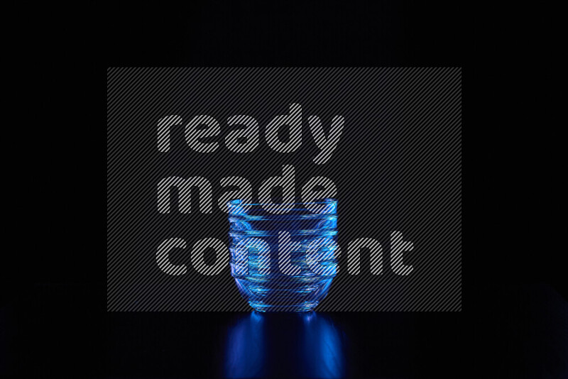 Glassware with rim light in blue against black background