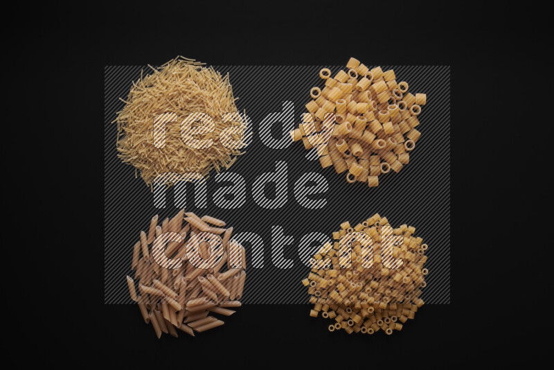 Different pasta types in bunches on black background