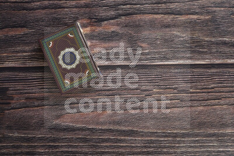 Quran with a prayer beads on wooden background