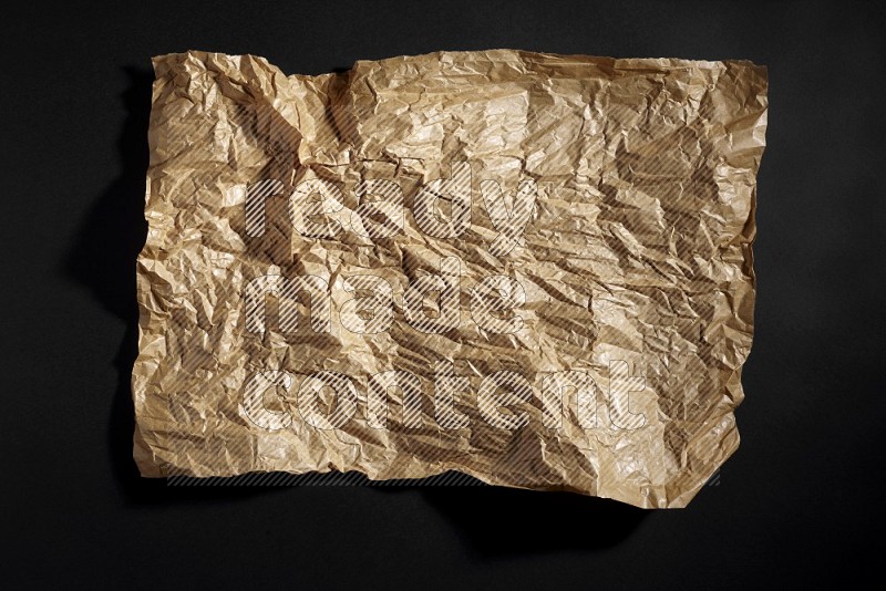 Crumpled craft paper on black background