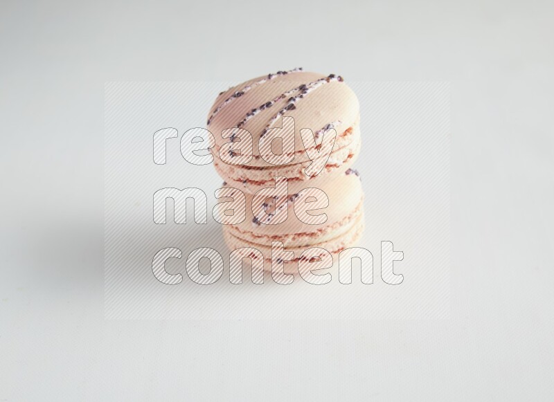 45º Shot of two pink orange blossom macarons on white background