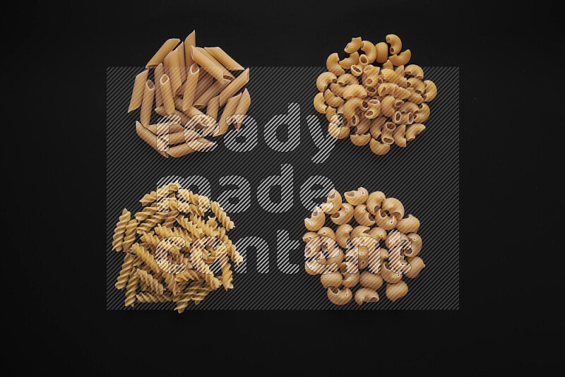 Different pasta types in bunches on black background