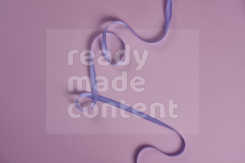 مجموعة من أدوات الخياطة والتفصيل أرجوانية وزهرية اللون على خلفية زهرية