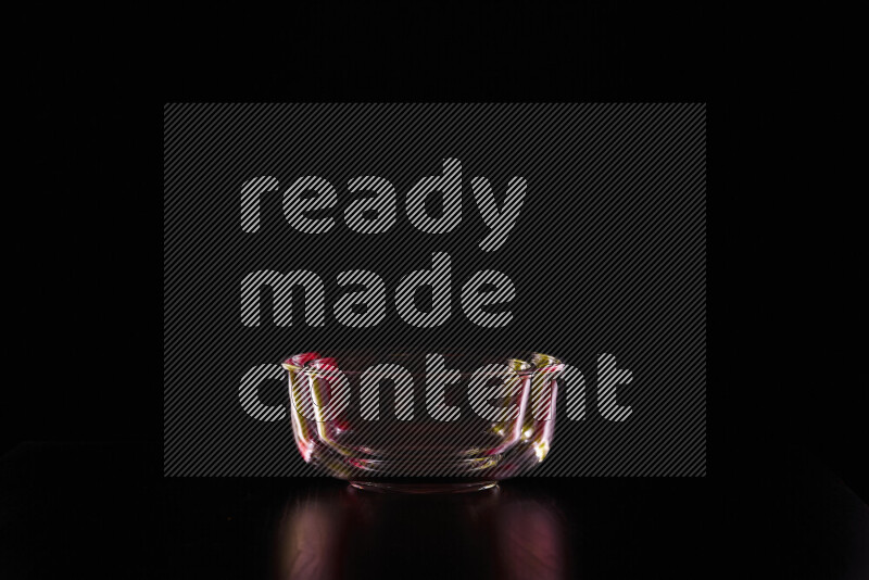 Glassware with rim light in red and yellow against black background