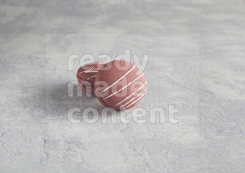 45º Shot of two Red Poppy Flower macarons on white  marble background