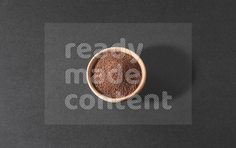 وعاء خشبي ممتلئ ببذور حب الرشاد علي خلفية سوداء