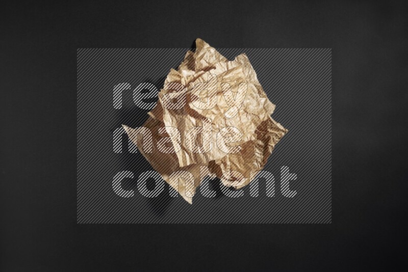 Crumpled craft paper on black background