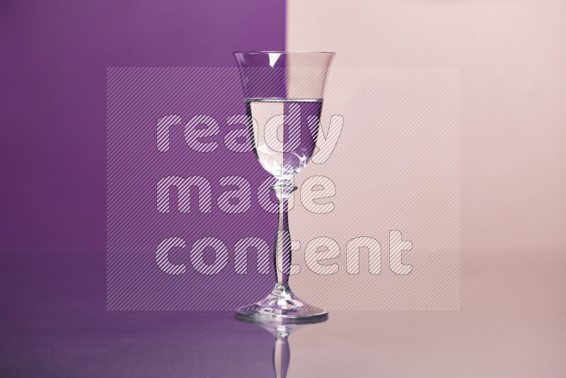 The image features a clear glassware filled with water, set against purple and rose background