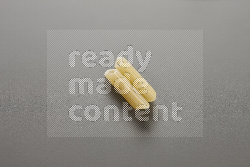 Mini penne pasta on grey background