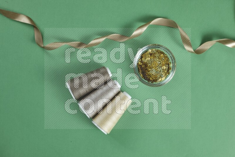 مجموعة من أدوات الخياطة والتفصيل بنية اللون على خلفية خضراء