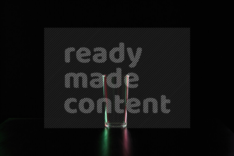 Glassware with rim light in red and green against black background