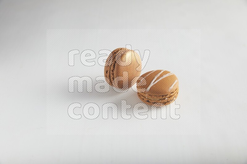 45º Shot of of two assorted Brown Irish Cream, and Brown Coffee macarons  on white background