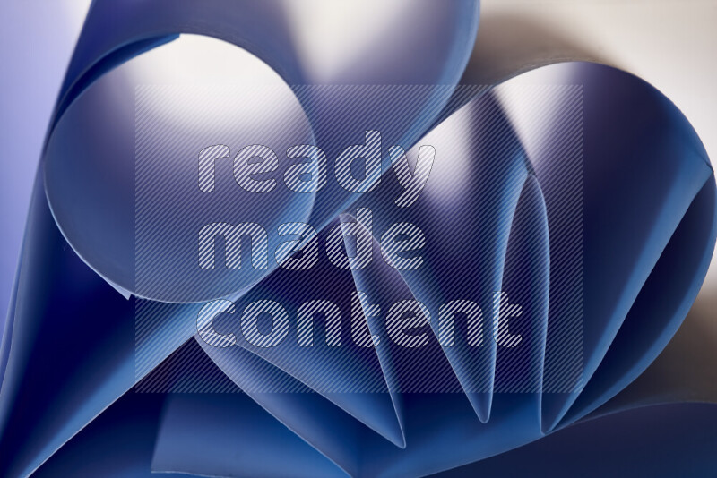 An artistic display of paper folds creating a harmonious blend of geometric shapes, highlighted by soft lighting in blue tones