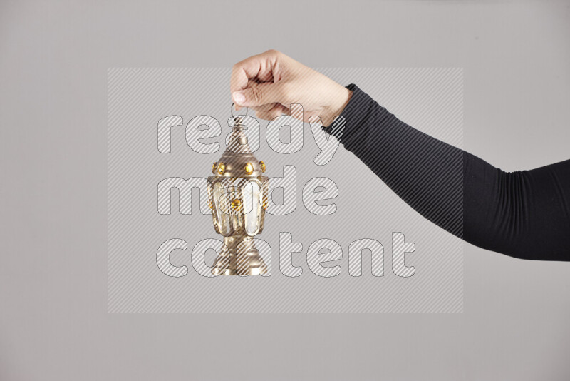 A woman in black abaya holding different ramadan lanterns in different positions