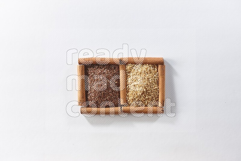 2 squares of cinnamon sticks full of flaxseeds and sesame on white flooring