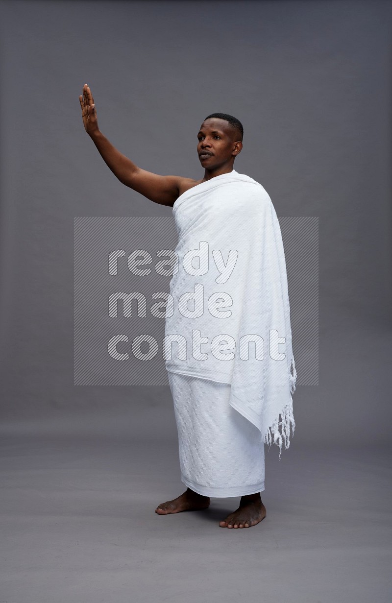 A man wearing Ehram Standing Interacting with the camera on gray background