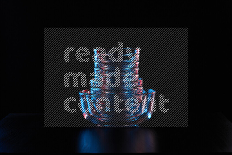 Glassware with rim light in red and blue against black background