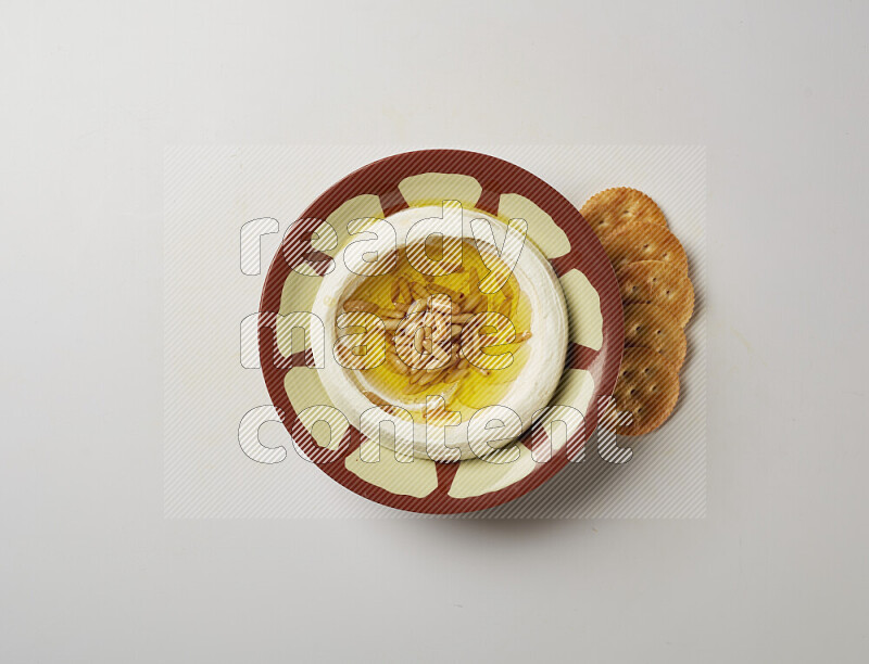 Lebnah garnished with pine nuts in a traditional plate on a white background