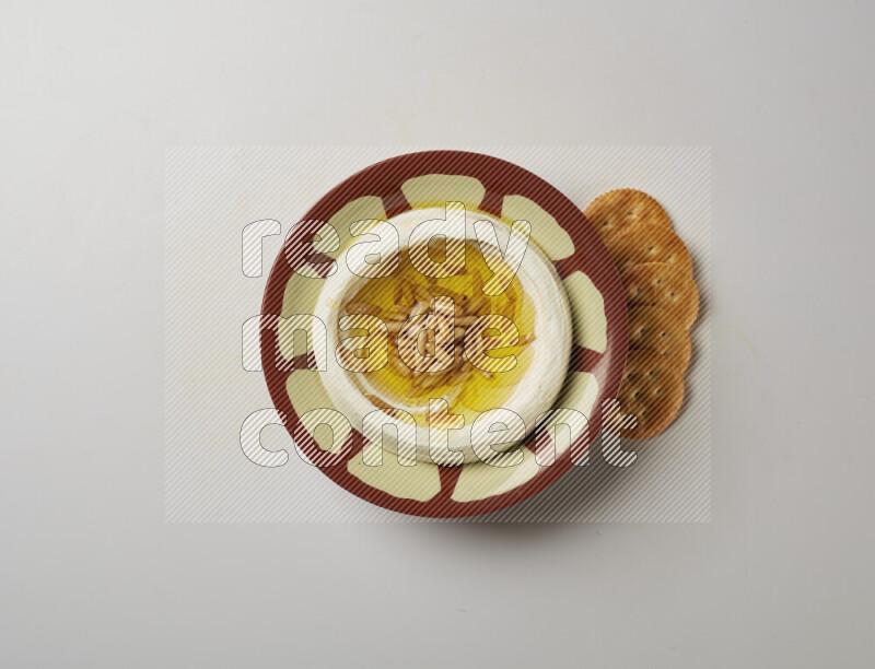 Lebnah garnished with pine nuts in a traditional plate on a white background