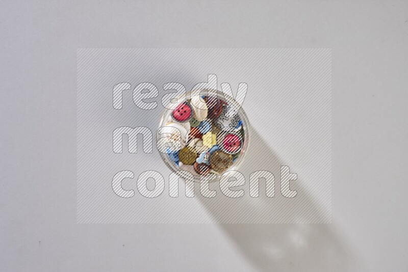 Mixed assorted buttons on grey background