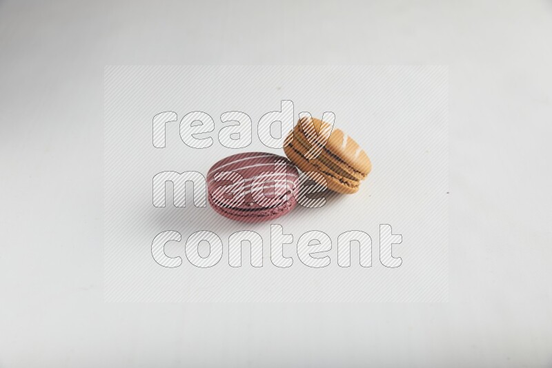 45º Shot of of two assorted Brown Irish Cream, and Red Poppy Flower macarons on white background
