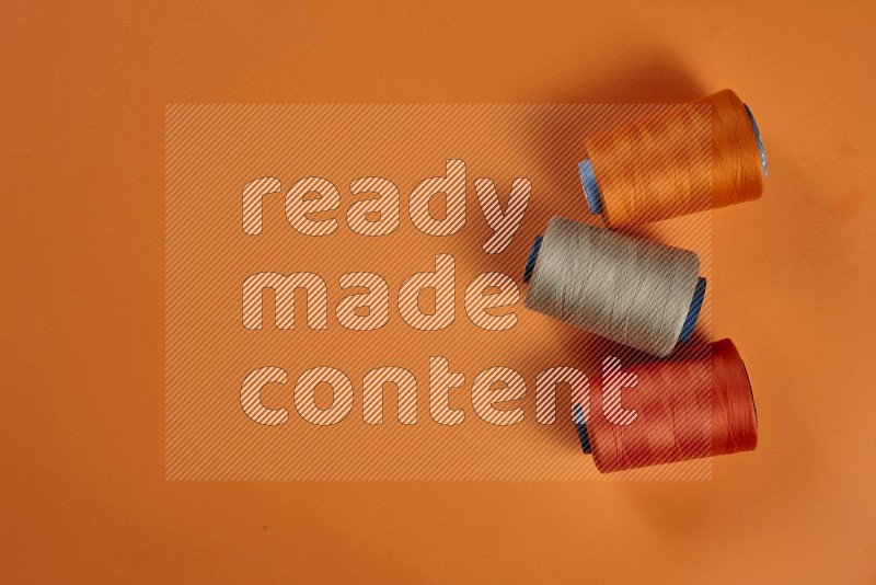 Brown sewing supplies on orange background