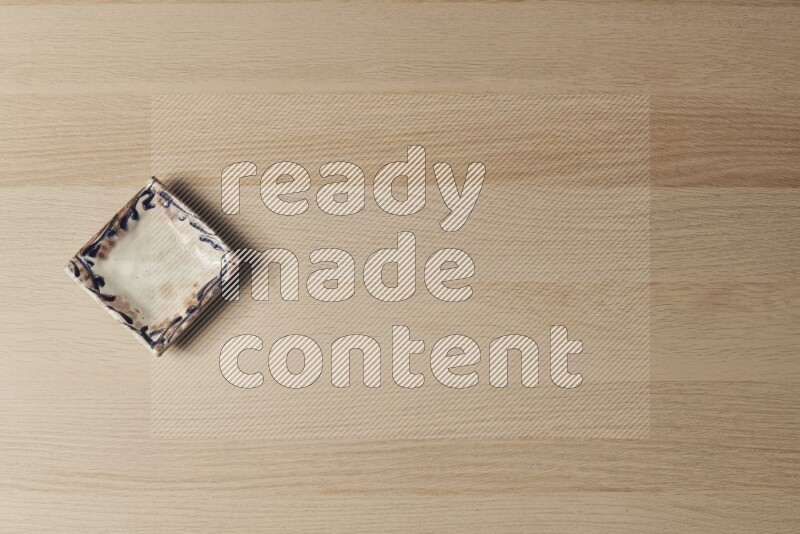 صحن فخاري مزخرف على خلفية خشبية فاتحة