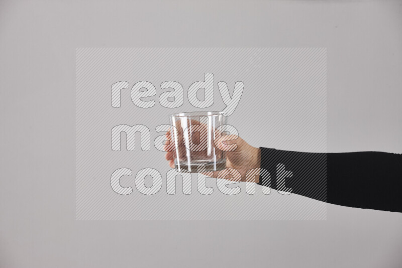 A woman in black abaya holding different glassware in different positions