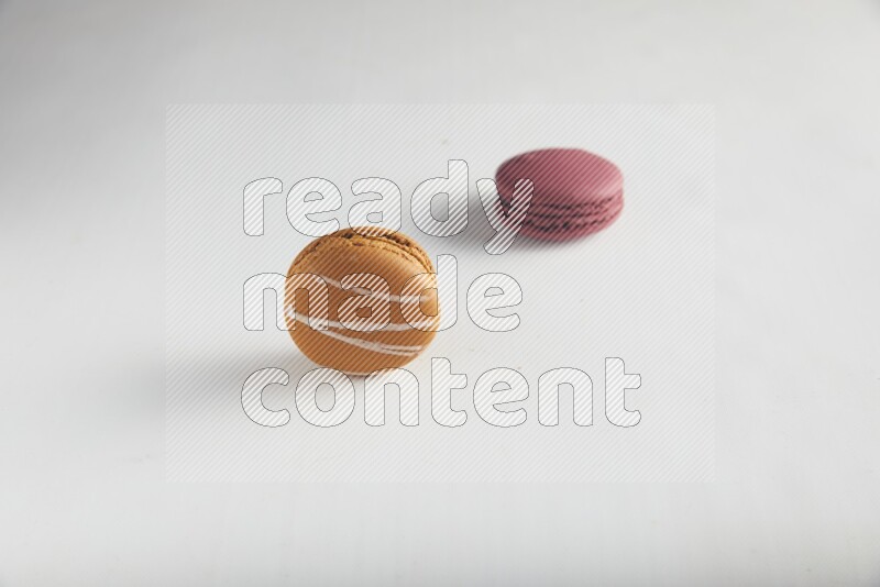 45º Shot of of two assorted Brown Irish Cream, and Red Cherry macarons on white background
