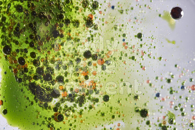 Close-ups of abstract green and red watercolor drops on oil Surface on white background