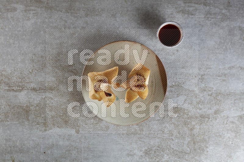 wonton cups with soy sauce ramkin on multi colored pottery on grey textured counter top
