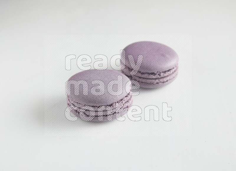 45º Shot of two Purple Blueberry macarons on white background