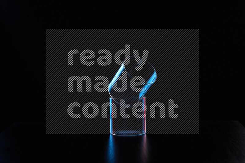 Glassware with rim light in red and blue against black background