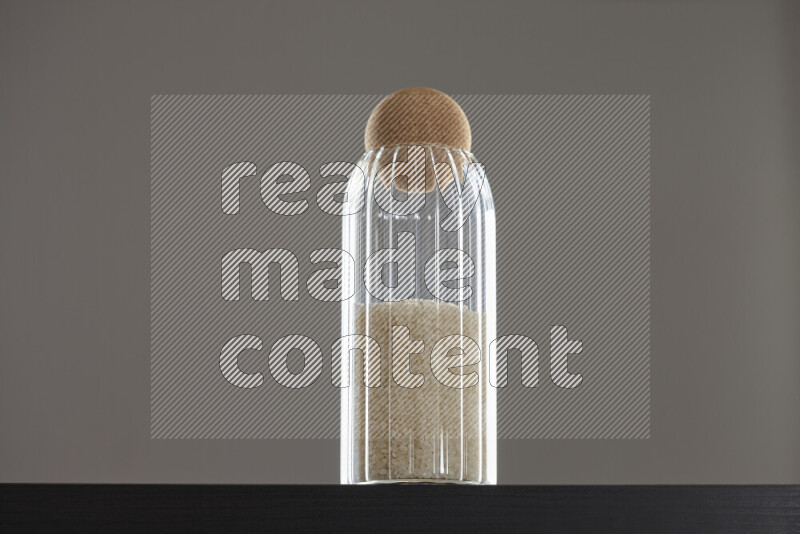 White rice in a glass jar on black background