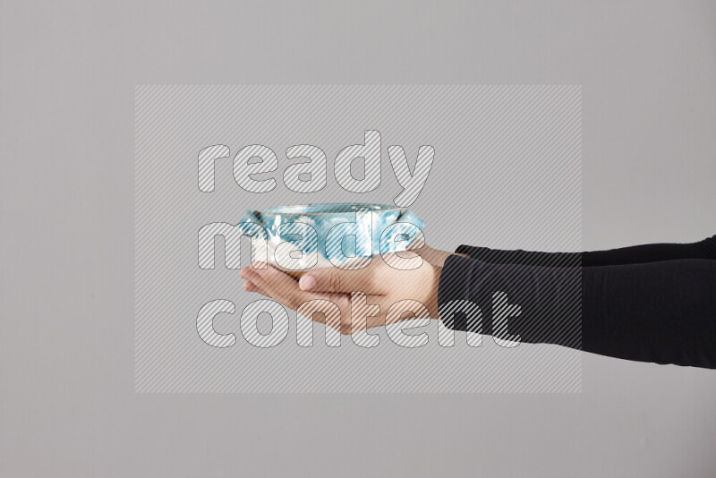 A woman in black abaya holding different pottery essentials in different positions