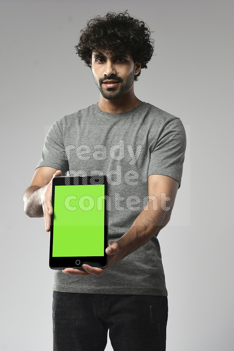 A man wearing casual standing and showing a tablet screen on white background