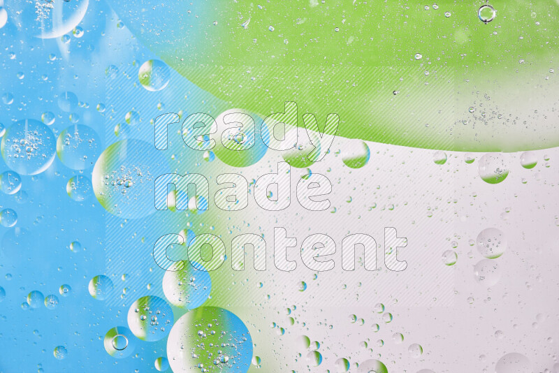 Close-ups of abstract oil bubbles on water surface in shades of white, green and blue