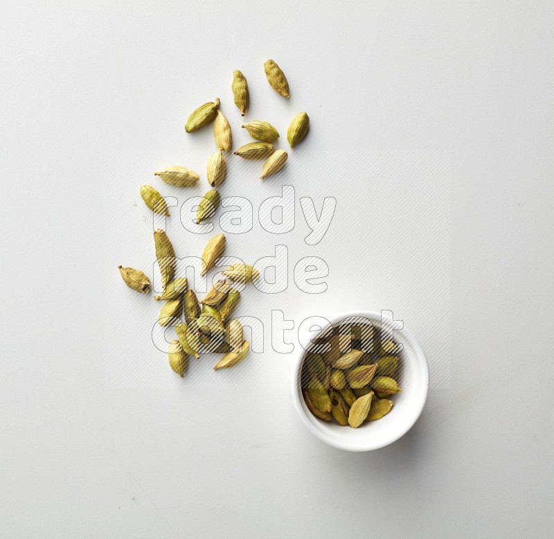 Top-view shot of Cardamon in a container on white background