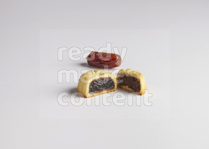Half Maamoul filled with date with Date on the side direct on white background