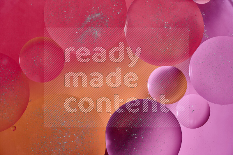 لقطات مقربة لفقاعات من الزيت على سطح الماء باللون الأحمر والبرتقالي والوردي